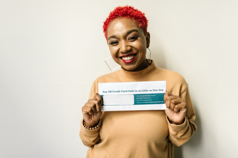 Happy woman holding an envelope, representing a debt free success story