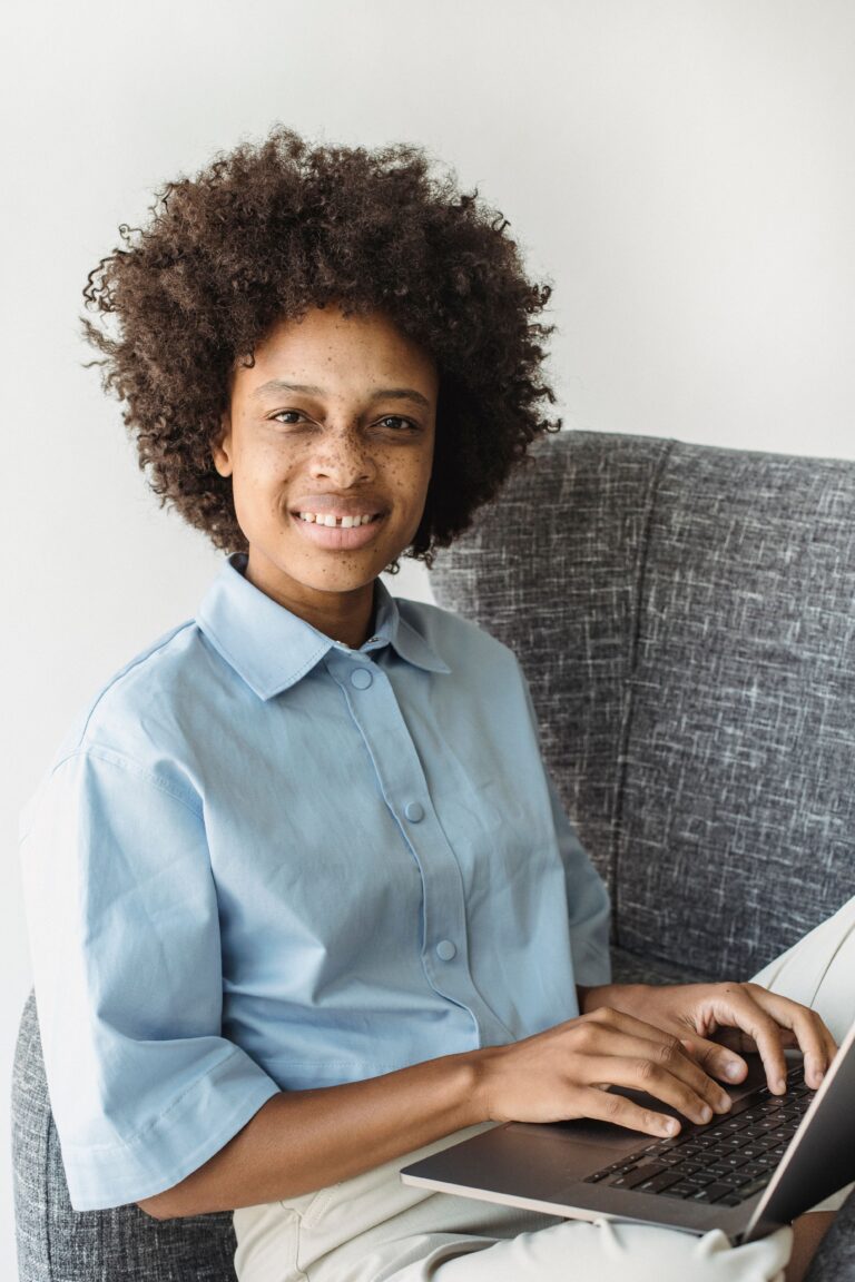 Woman relaxed on her couch working a no-interview remote job on a laptop